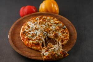 Hot cheesy pizza with bell peppers on a wooden platter. Perfect for food lovers.